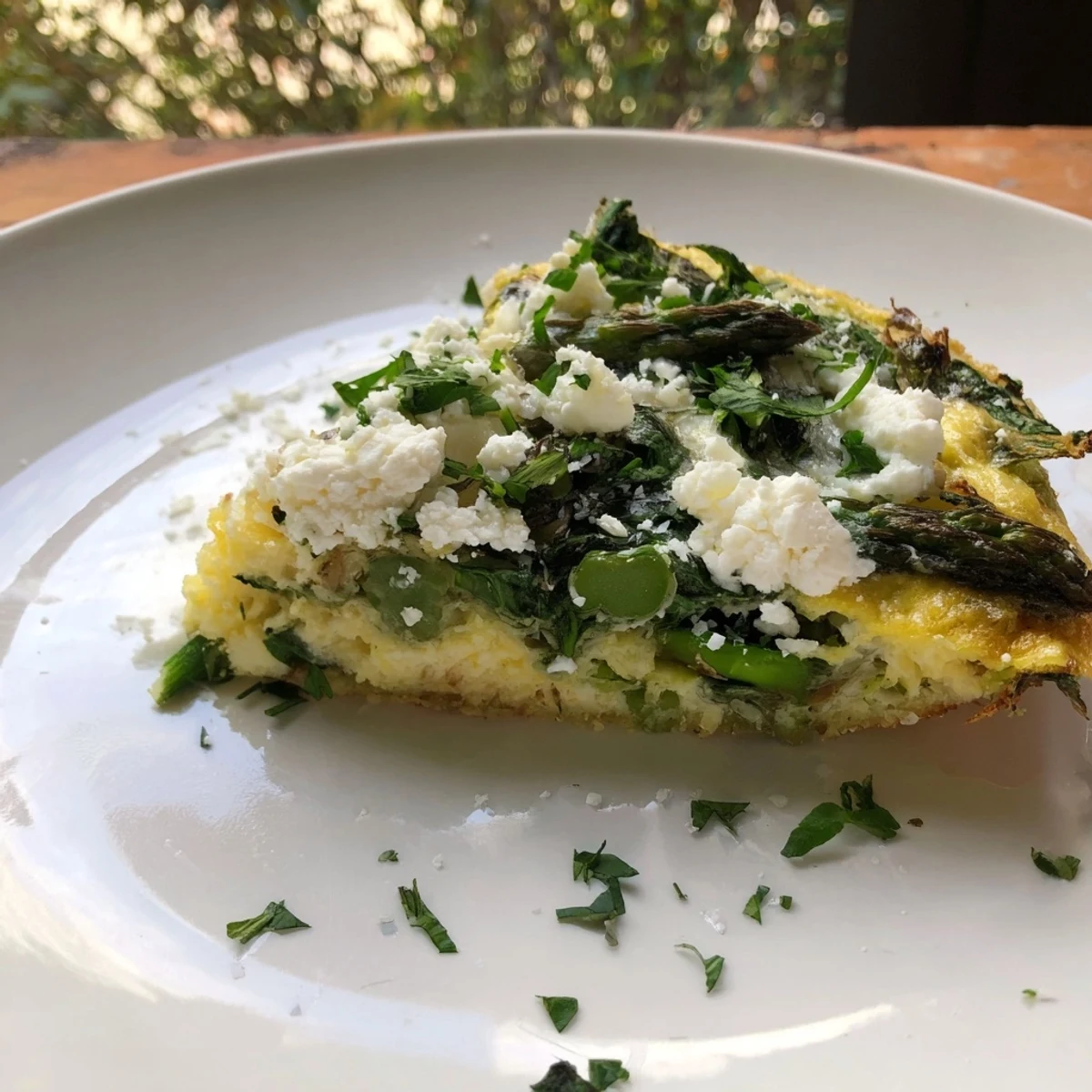 Golden, fluffy Meadow-Soft Cozy Plate: Frittata with Spring Greens holding a creamy goat cheese topping.