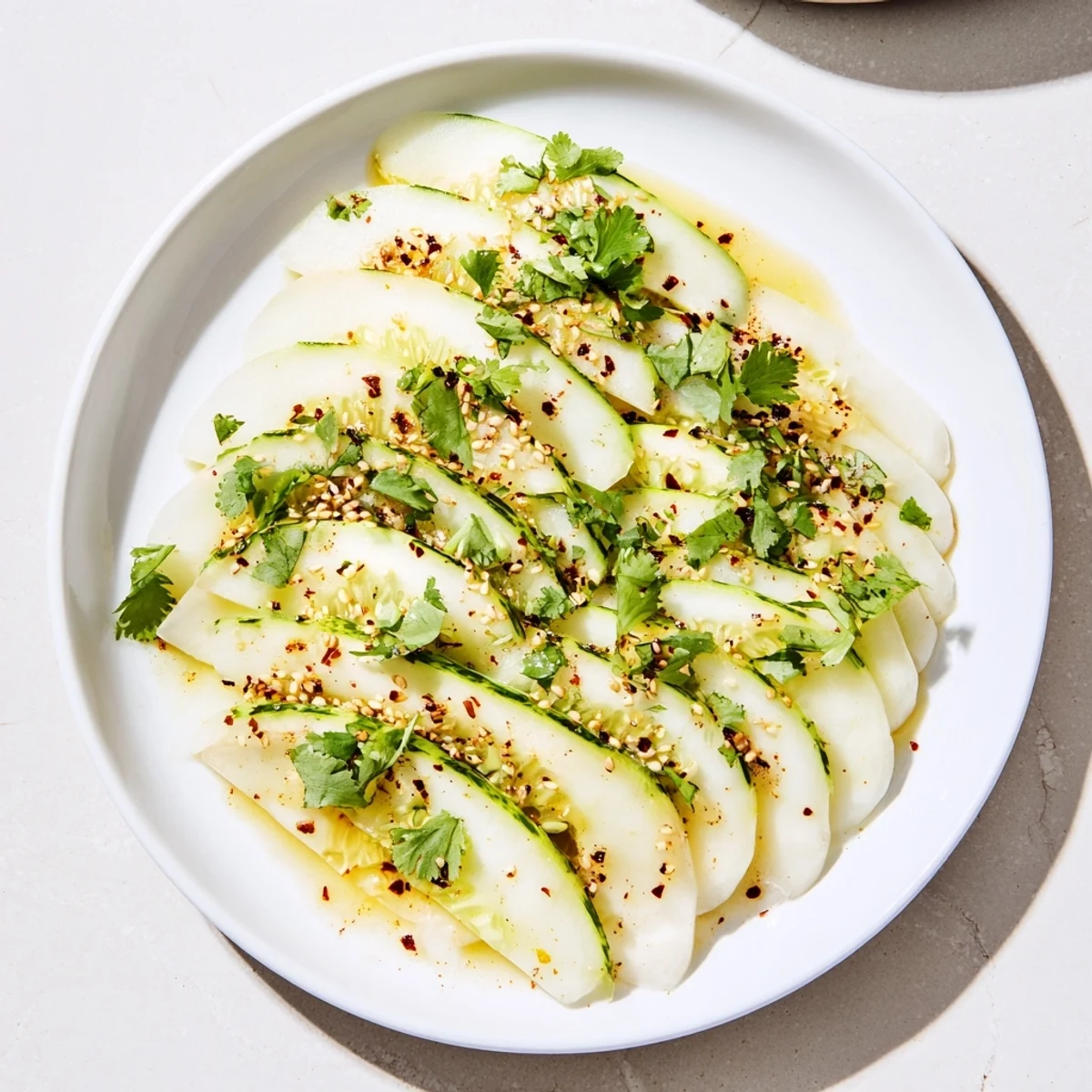 Layered Jicama and Cucumber Slice Stack, a refreshing vegan starter topped with chopped cilantro.