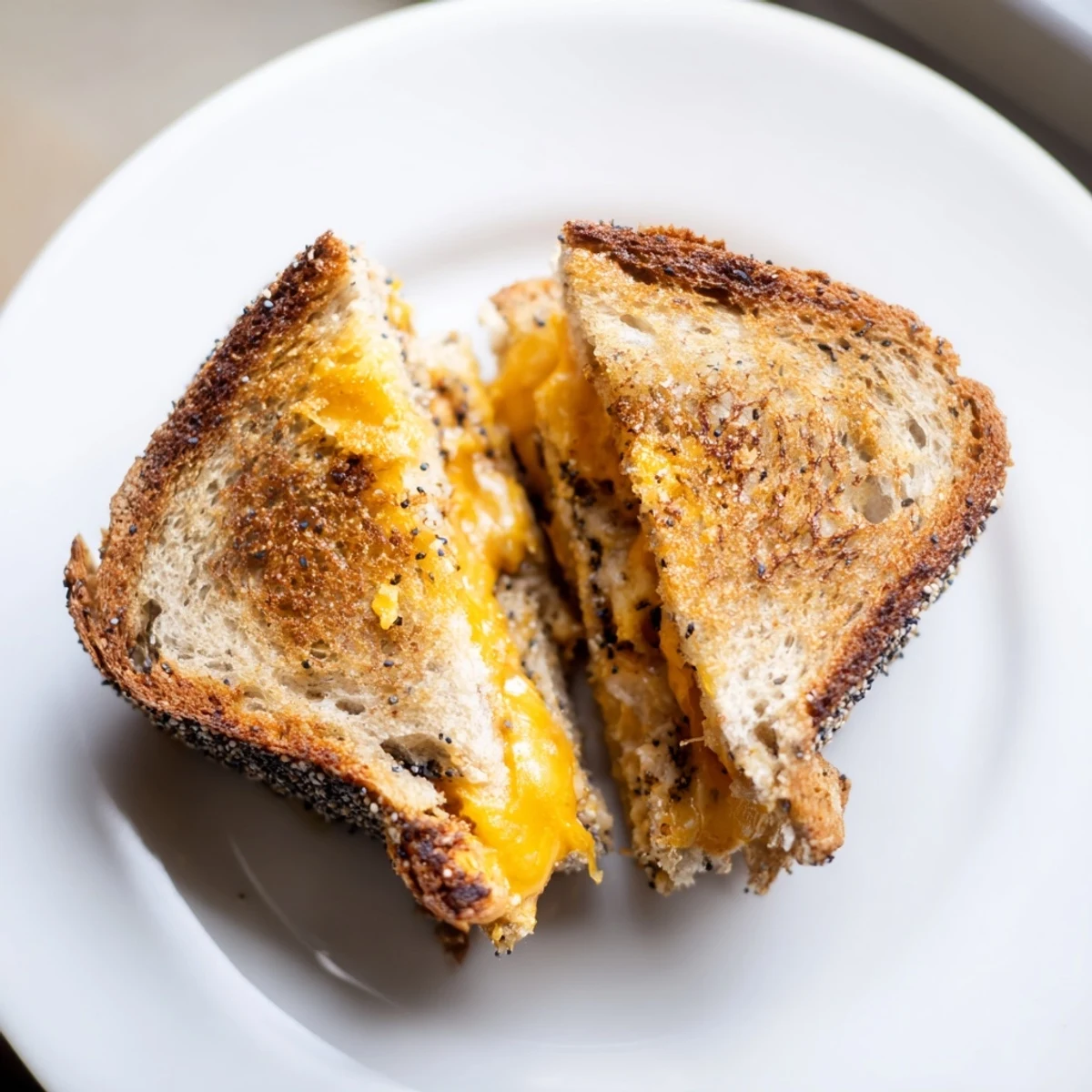 Golden-brown everything bagel grilled cheese, cheddar oozing, a comforting, melty, and savory lunch.