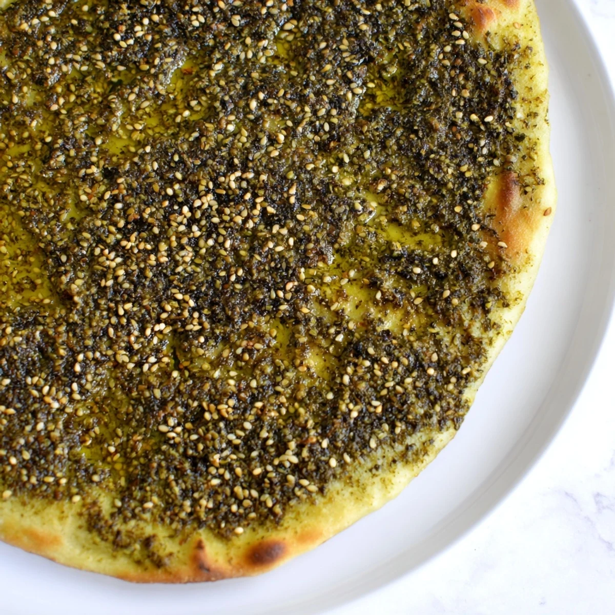 Golden-brown Levantine Zaatar Bread, glistening with olive oil and aromatic zaatar spice mixture.