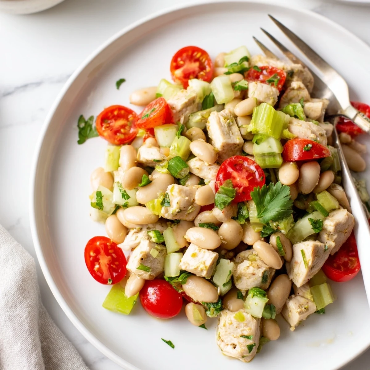 A vibrant bowl of Lemony White Bean Chicken Salad features tender chicken, creamy beans, and crisp celery in a bright lemon vinaigrette.  