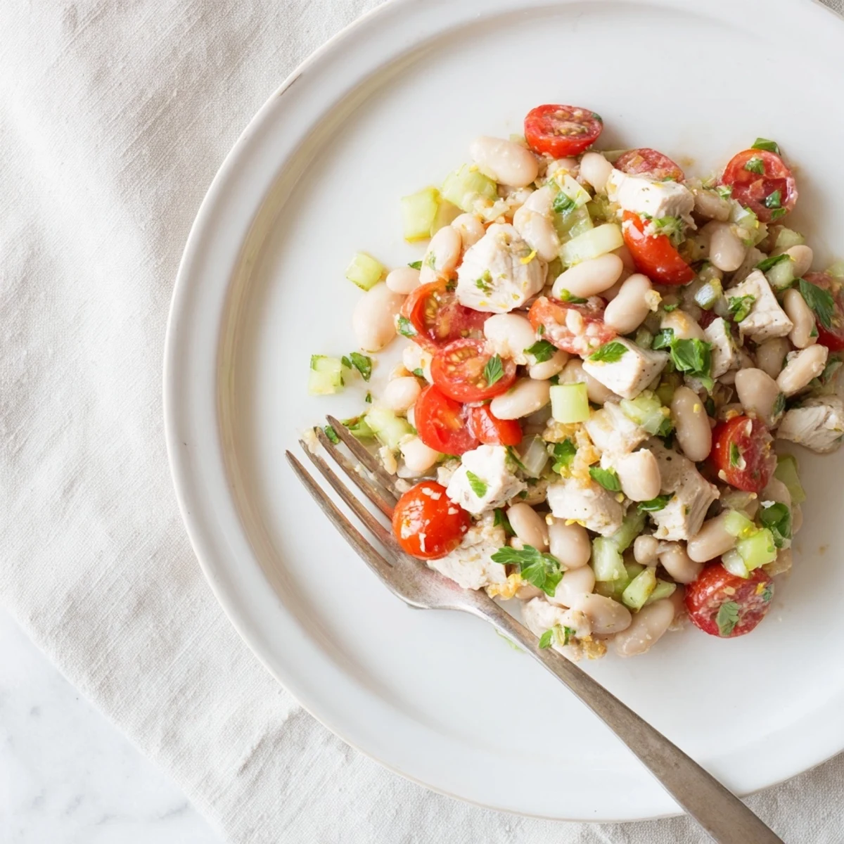 Bright, fresh flavors of Lemony White Bean Chicken Salad are tossed with herbs and cherry tomatoes for a refreshing bite.