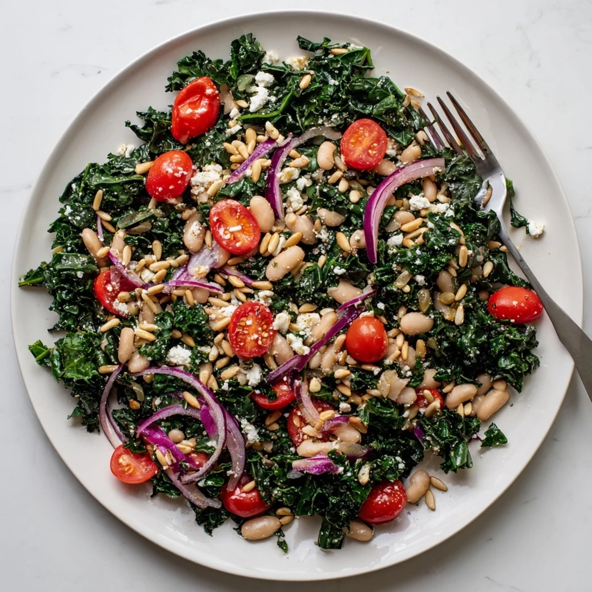 A vibrant White Bean and Kale Salad features creamy cannellini beans, crisp kale, and halved cherry tomatoes tossed in a bright lemon-garlic vinaigrette.  