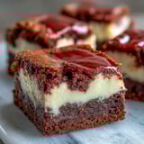 Slice of Red Velvet Cheesecake Brownies served on a white plate with a glass of milk.