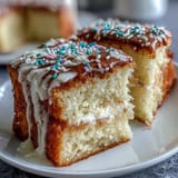 Fluffy vanilla sheet cake with creamy buttercream frosting, decorated with festive graduation-themed sprinkles for a celebratory dessert centerpiece.