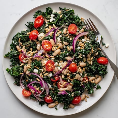 A vibrant White Bean and Kale Salad features creamy cannellini beans, crisp kale, and halved cherry tomatoes tossed in a bright lemon-garlic vinaigrette.  