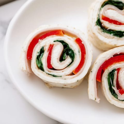 Showcasing perfectly sliced turkey and provolone pinwheels ready to serve as a tasty appetizer.