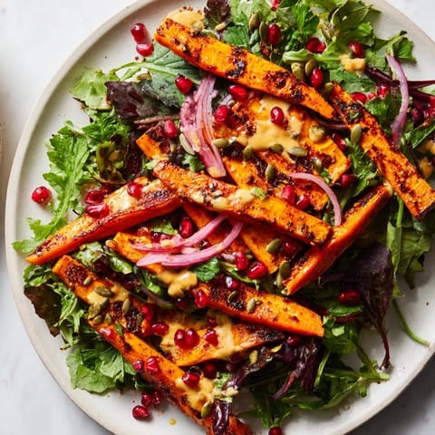 Brightly colored roasted carrots mingle with greens; this delicious salad is drizzled with creamy tahini.