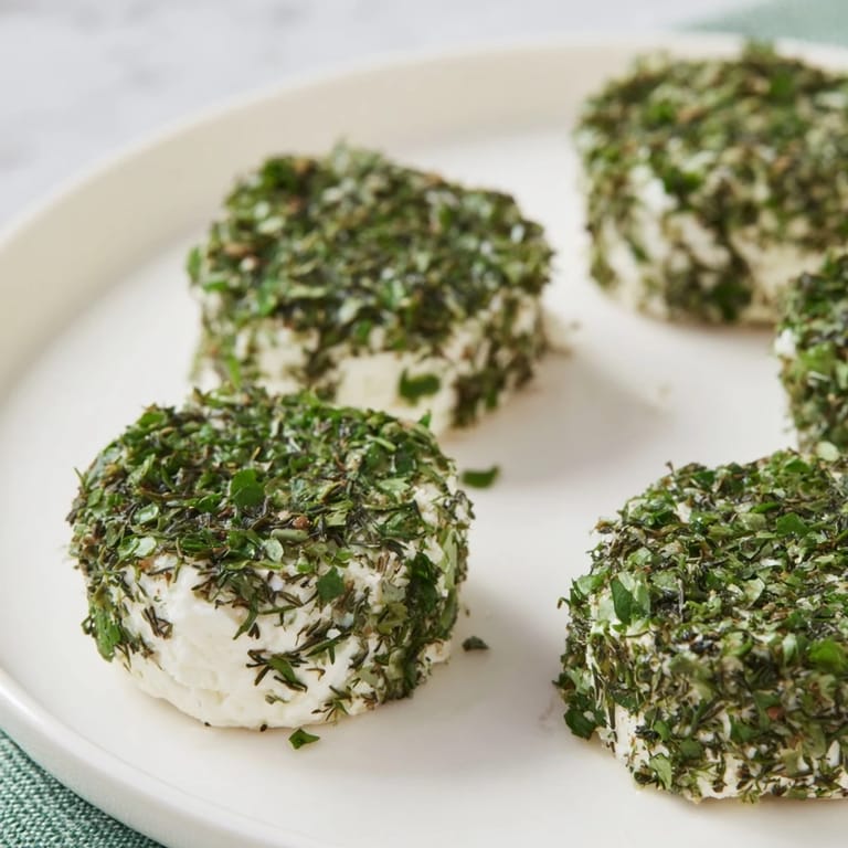 Freshly coated "Mossy Stone" cheese bites garnished with edible flowers; a perfect party appetizer.