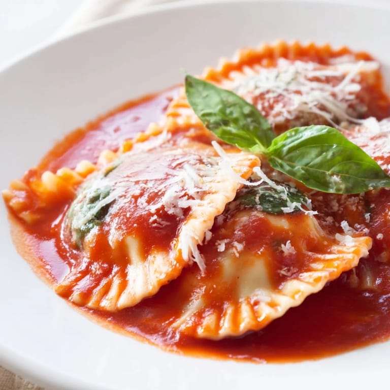 Steaming Spinach Ricotta Ravioli plated with marinara and basil, ready for a comforting Italian dinner.  
