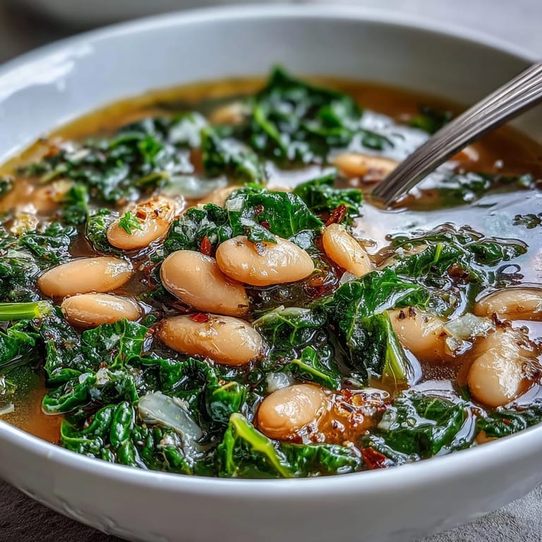 Hearty white beans and tender kale simmer in a fragrant broth infused with lemon zest and garlic in this nourishing soup.
