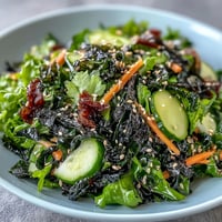 A vibrant seaweed and nori salad with crisp greens, crunchy seaweed snacks, and a zesty ginger-soy dressing.  